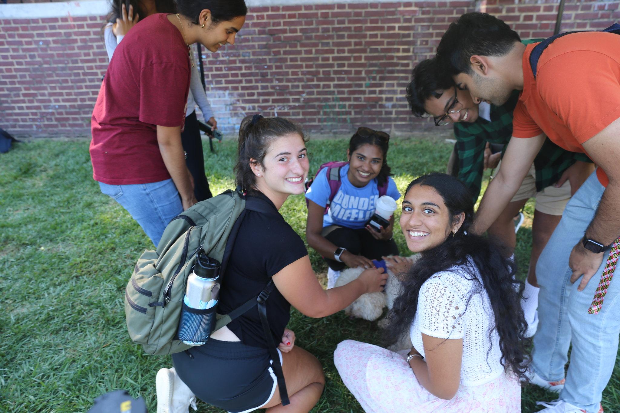 group of students petting therapy dog on McKeldin Mall during Mental Health Awareness Week