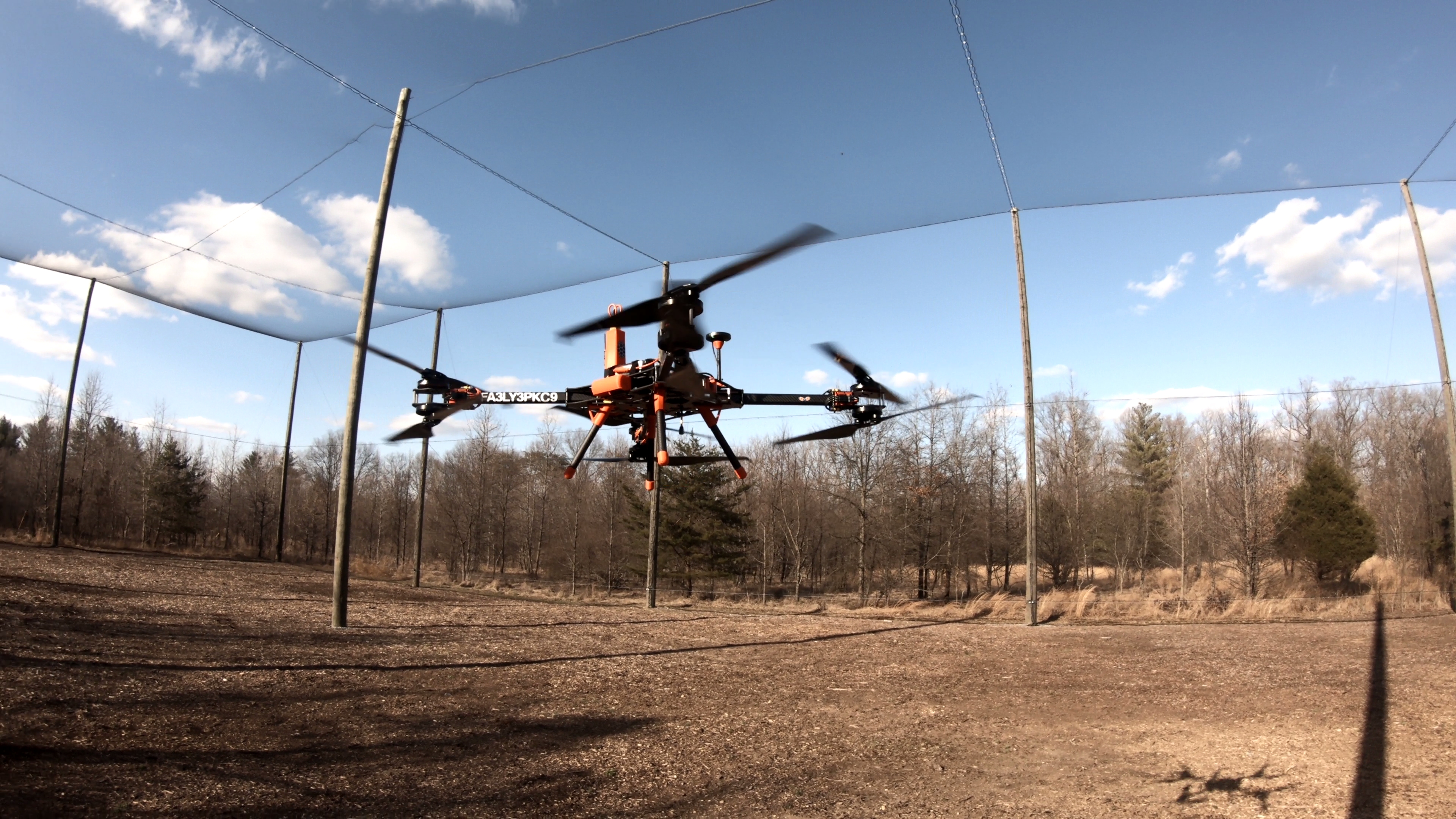 A drone in the air surrounded by protective netting