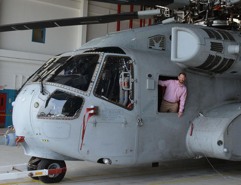 Scott Green leaning out of a Sikorsky helicopter