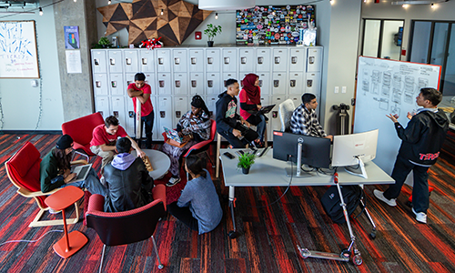 a group of students work in the Startup Shell surrounding a table