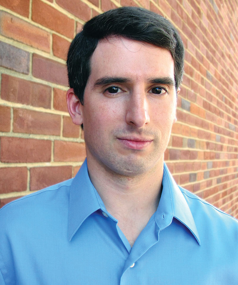 Headshot of Edo Waks wearing a sky blue button down shirt