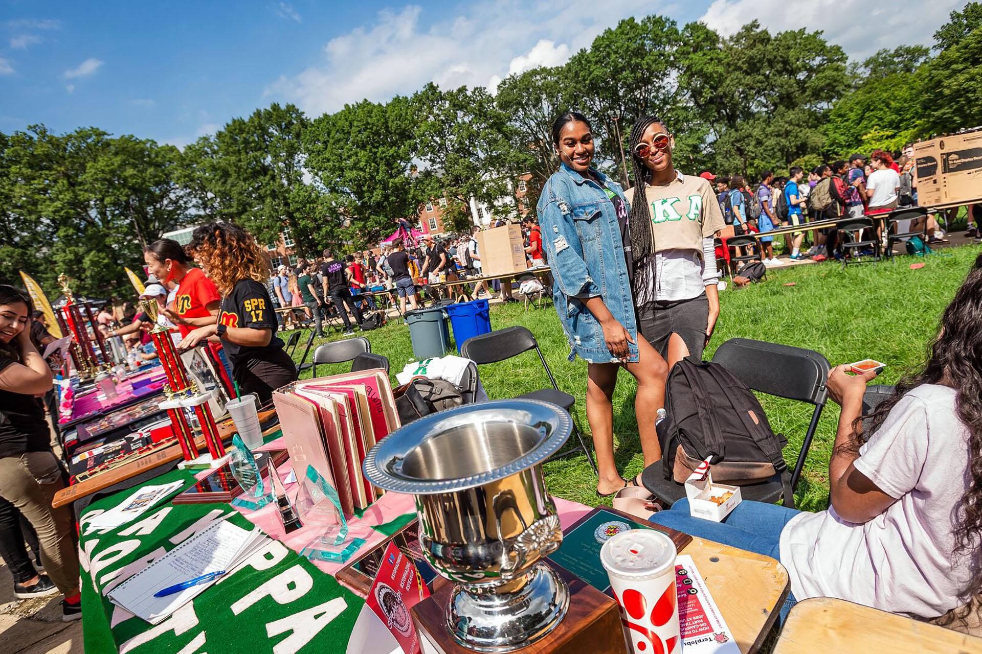 two sorority students posing behind a table during the first look fair