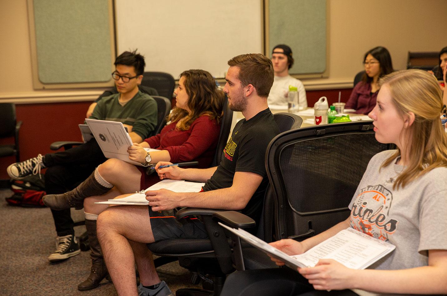 students in conference room engaging in dialogue